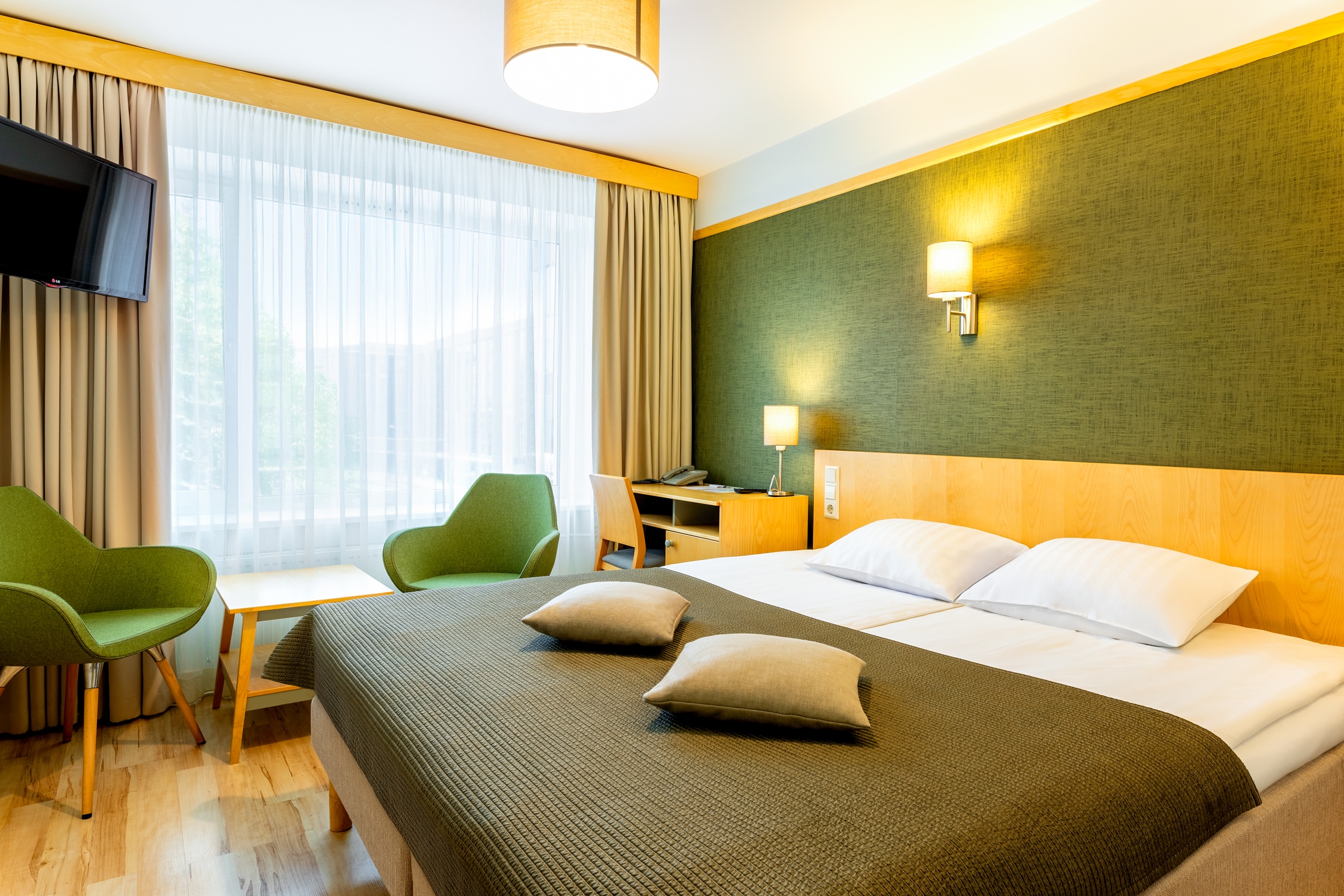 Hotell Tartu standard tuba kaheinimesevoodiga ja roheliste tugitoolidega -hotellituba Tartus