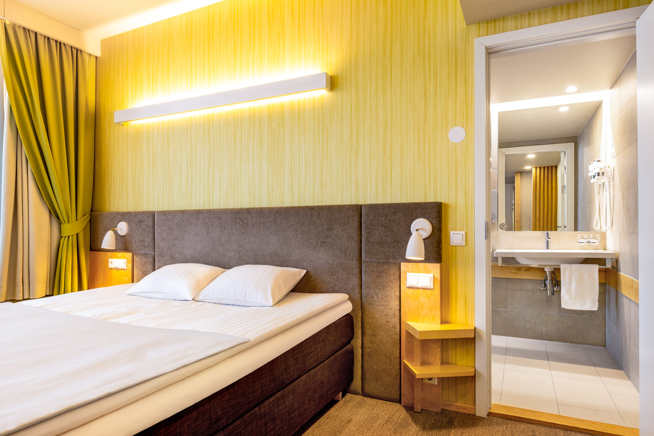 Hotell Tartu Deluxe tuba kaheinimesevoodi ja kollase seinaga - suure vannitoaga Deluxe tuba Tartus