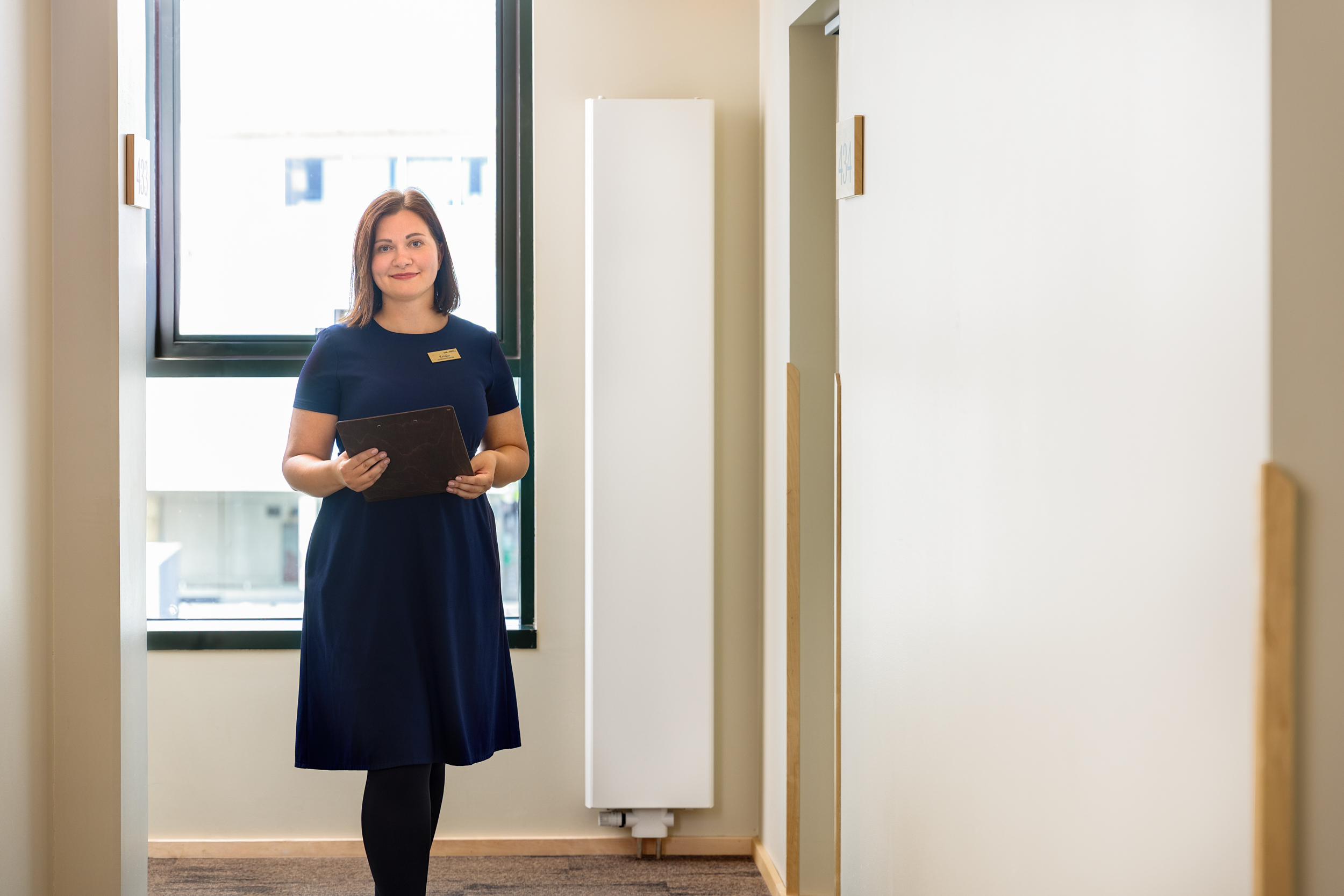 Hotell Tartu töötaja hotellikoridoris numbritubade juures - professionaalne teenindus Tartu hotellis