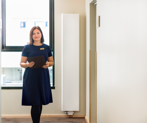 Hotell Tartu töötaja hotellikoridoris numbritubade juures - professionaalne teenindus Tartu hotellis
