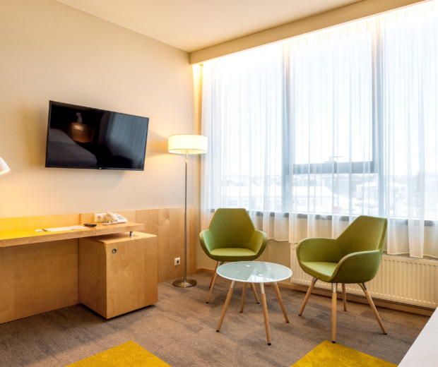 Hotell Tartu Deluxe toa istumisala kahe rohelise tugitooli ja suure aknaga - ruumikas Deluxe tuba Tartus